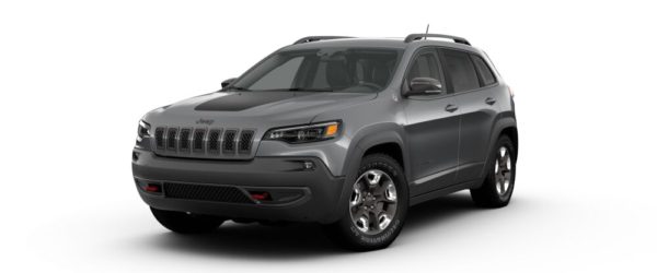 A gray jeep cherokee is parked on the street.