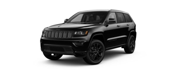 A black jeep grand cherokee parked in front of a white wall.